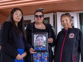 Family of Earl Burns and Deborah Burns, left to right, daughters Vanessa Burns and Joyce Burns, wife, hold a photograph of Earl following a Saskatchewan RCMP preliminary timeline presentation of the events during a media event in Melfort, Sask in April 27, 2023.