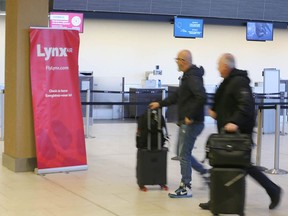 Passengers pass the Lynx Air check-in desk at the Calgary International Airport on Friday.