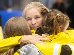 Jennifer Jones hugs her daughters after the Scotties final.