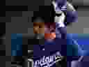加利福尼亚州阿纳海姆 - 3 月 26 日：2024 年 3 月 26 日在阿纳海姆天使体育场对阵洛杉矶天使队的表演赛中，洛杉矶道奇队的 Shohei Ohtani #17 在第三局三振后摘下教练席上的头盔，加利福尼亚州。