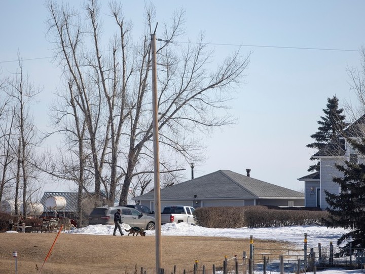  An RCMP vehicle is stationed outside a farmhouse near the town of Neudorf on March 26, 2024, a day after RCMP announced an investigation into the suspicious deaths of four people found in a rural residence in the area.