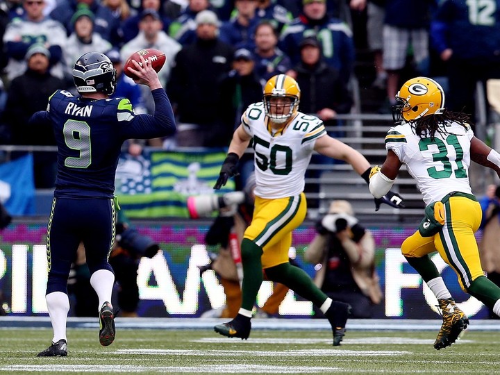  Jon Ryan #9 of the Seattle Seahawks throws a 19 yard touchdown pass to Garry Gilliam #79 in the second half against the Green Bay Packers during the 2015 NFC Championship game at CenturyLink Field on January 18, 2015 in Seattle, Washington.