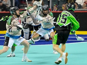 Shane Simpson (left) and Reece Callies of the Calgary Roughnecks defend against Ryan Keenan of the Saskatchewan Rush on WestJet Field at Scotiabank Saddledome on Friday, April 5, 2024. Cliff McCaig/NLL