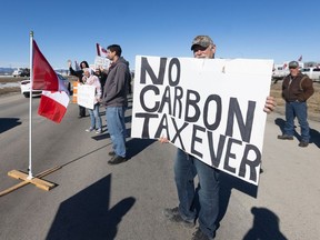 Demonstrators line the Trans-Canada Highway west of Calgary protesting the carbon tax on Monday, April 1, 2024. The Trans-Canada was reduced to one lane by the demonstrators west of the Highway 22 junction. Brent Calver/Postmedia