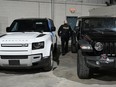 An Ontario Provincial Police officer walks between two recovered stolen vehicles during a news conference in Montreal, Wednesday, April 3, 2024. The federal Liberals are trying to crack down on a scourge of auto thefts across the country, even as the government is struggling to keep its own vehicles away from thieves, new data show.