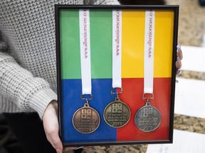 Gold, silver and bronze medals are sitting in a display box held by a staff member of the retirement home.