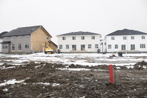 A home still being constructed stands next to two already built homes