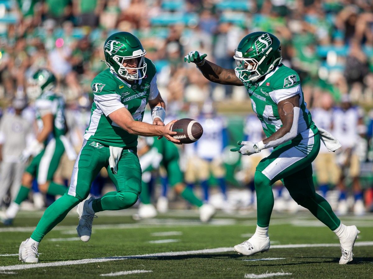 Saskatchewan Roughriders quarterback Jack Coan (14) hands off the football to Saskatchewan Roughriders running back Mario Anderson Jr. (24) during the first half of CFL preseason football action against the Winnipeg Blue Bombers at Griffiths Stadium in Saskatoon, Sask.,, on Saturday, May 23, 2026.