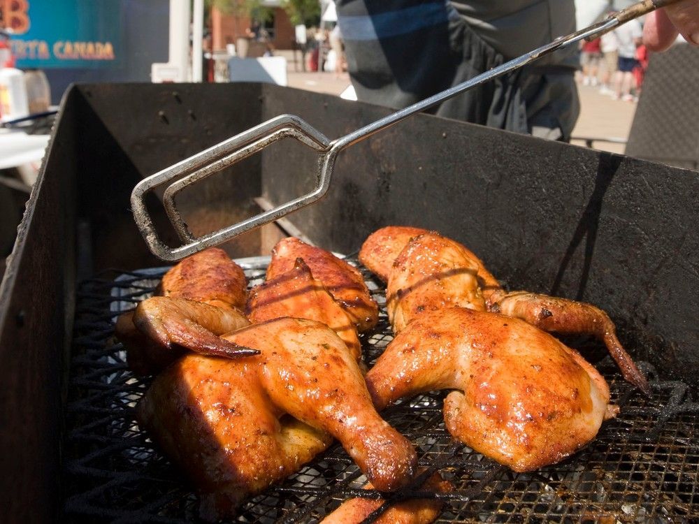 Chicken cooks on a barbecue.