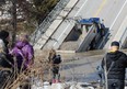 Onlookers gather at the collapsed Imperial Road bridge in Port Bruce on Sunday. The structure gave out while a fully-loaded dump truck was driving across it Friday. (DALE CARRUTHERS, The London Free Press)