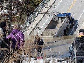 Onlookers gather at the collapsed Imperial Road bridge in Port Bruce on Sunday. The structure gave out while a fully-loaded dump truck was driving across it Friday. (DALE CARRUTHERS, The London Free Press)