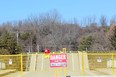 A sign warns motorists at the collapsed Imperial Road bridge in Port Bruce on Sunday. The structure gave out while a fully-loaded dump truck was driving across it Friday. (DALE CARRUTHERS, The London Free Press)