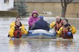 Members of the Chatham-Kent fire service dive team help residents whose homes were flooded in Chatham.  (Louis Pin/Postmedia News)