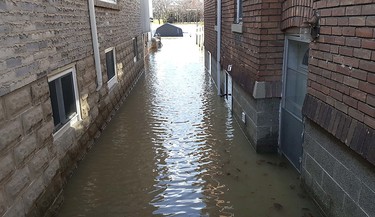 Floodwaters from the Thames River reached between these two homes on William Street North in Chatham, Ont. on Sunday February 25, 2018. (Trevor Terfloth/Postmedia News)