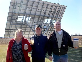 Chatham Township residents Angie and Jim Leveille, left, and Rick Goetheyn hold samples of water from their wells Tuesday, days after turbines with the North Kent Wind farm began operating north of Chatham. (ELLWOOD SHREVE, Chatham Daily News)