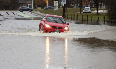 A motorist, drives into the raised median on a closed section of Wonderland Road just north of the Guy Lombardo bridge in London, Ont. on Wednesday February 21, 2018. The motorist was unable to head south in the southbound lanes because they were closed with blockades, so they drove south in the northbound lanes, on a closed road through a flooded section of roadway. Mike Hensen/The London Free Press/Postmedia Network