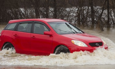 A motorist, drives south on the northbound lanes of a flooded and closed section of Wonderland Road just north of the Guy Lombardo bridge in London, Ont. on Wednesday February 21, 2018. The motorist was unable to head south in the southbound lanes because they were closed with blockades, so they drove south in the northbound lanes, on a closed road through a flooded section of roadway. Mike Hensen/The London Free Press/Postmedia Network