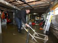 Mark Blockeel, owner of Paul Davis Restoration, positions a hose draining a flooded basement on Walnut Street in London. Water still blocks the small street southwest of Riverside Drive and Wharncliffe Road. Most homes on the street suffered some flooding. Blockeel said this homeowner will have to replace a furnace, hot-water tank and other basement appliances still awash in 15 to 20 centimetres of water. (MIKE HENSEN, The London Free Press)