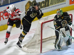 Ottawa 67’s forward Travis Barron slams into Knights defenceman Alec Regula behind the London net during the first period of their OHL game at Budweiser Gardens on Friday night.  (MORRIS LAMONT, The London Free Press)