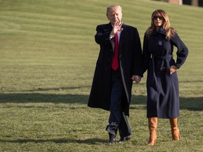 U.S. President Donald Trump walks with First Lady Melania Trump on the South Lawn of the White House March 19, 2018.