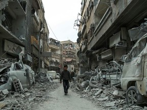 A Syrian child walking down a street past rubble from destroyed buildings, in the rebel-held town of Douma in the Eastern Ghouta enclave on the outskirts of Damascus on Thursday. (HAMZA AL-AJWEH/AFP/Getty Images)