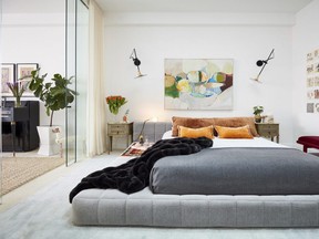 It takes a careful touch, but homeowners can consider moving a piece of art they already own — such as this striking piece in a bedroom designed by Jenny Dina Kirschner — from one room to another as a cost-free way of redecorating their space for a  change of decor. Greenery and fresh flowers can also perk up a room. Keep costs down by choosing plants with a long shelf life. (photos: Ryan Dausch/JDK Interiors)