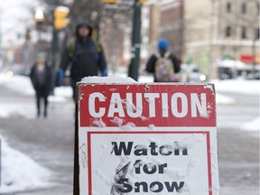 Pedestrians on Wellington Street are warned to watch for snow falling from Citi Plaza in London, Ont. on Wednesday February 7, 2018.  (DEREK RUTTAN, The London Free Press)