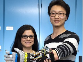 Engineering professor Ana Luisa Trejos and student Yue Zhou demonstrate a tremor suppression glove developed at Western University. The device offers people with Parkinson’s disease improved motor control. (Derek Ruttan/The London Free Press)