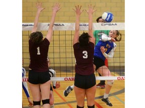 Hannah Petcoff of Oakridge drives a spike down the line past the block of Grace Mazur and Babelonea Hawel of St. Jean de Brebeuf during their Pool C game at the OFSAA AAA girls volleyball championship at Oakridge on Monday. The host school won 25-23, 25-22. (Mike Hensen/The London Free Press)