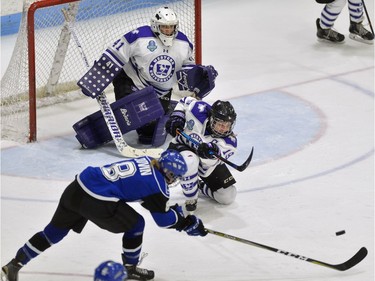 Western Mustang defenceman Emma Pearson fires a rebound out of harm's way past  Montreal Carabins forward Estelle Duvin in front of goaltender Camen Lasis during their game in the Women's Hockey National Championship at Western University's Thompson Arena on Thursday. (MORRIS LAMONT/THE LONDON FREE PRESS)