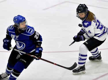 Western Mustang forward Rachel Armstrong keeps her eyes on a loose puck with Montreal Carabins forward Catherine Dubois during their game in the Women's Hockey National Championship at Western University's Thompson Arena on Thursday. (MORRIS LAMONT/THE LONDON FREE PRESS)