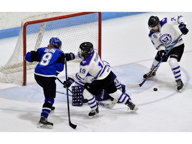 Western Mustang defenceman Emma Pearson blocks Montreal Carabins forward Estelle Duvin while defenceman Renae Nevills clears the rebound in front of goaltender Camen Lasis during their game in the Women's Hockey National Championship at Western University's Thompson Arena on Thursday. (MORRIS LAMONT/THE LONDON FREE PRESS)