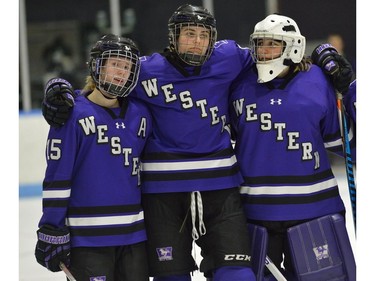 Western Mustangs Megan Taylor, Anthea Lasis and Carmen Lasis, watch the medal presentation after losing the U Sports women’s hockey national championship 2-0 to the Manitoba Bisons at Western University’s Thompson Arena Sunday. (MORRIS LAMONT, The London Free Press)