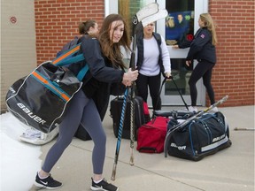 Michaela Landers of the Medway Cowboys girls hockey team hauls her gear toward a bus in London on Tuesday as the team gets ready to drive to Cambridge to begin their defence of their OFSAA AAA hockey championships. (Mike Hensen/The London Free Press)