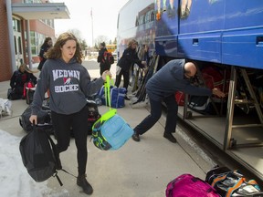 Maddy Melo hauls her gear to the bus at the school Tuesday as the Medway girls hockey team heads to Cambridge to begin their defence of their OFSAA AAA championship. (MIKE HENSEN, The London Free Press)