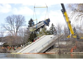 A crane lifts a dump truck that was stuck for weeks on a collapsed bridge near Port Bruce on Friday, March 23. Derek Ruttan/The London Free Press