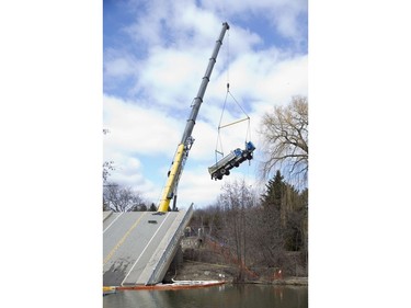 Stranded for weeks on a collapsed bridge, a dump truck is finally liberated by crane in Port Bruce on Friday March 23, 2018. Derek Ruttan/The London Free Press