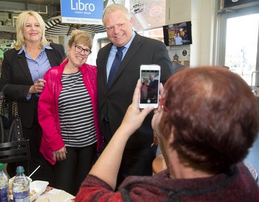 Alice Kelly poses for a photo being taken by her friend Valerie Sawczuk with local PC candidate Susan Truppe and PC leader Doug Ford Doug at the Covent Garden Market. Ford stopped at the popular lunch spot on Monday to shake hands with Londoners as part of his campaign swing through southwestern Ontario on Monday March 26, 2018.  Mike Hensen/The London Free Press/Postmedia Network