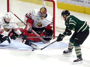 Cole Tymkin of the Knights tries a backhand in close on Owen Sound goalie Olivier Lafreniere while defenseman Trenton Bourque tries for the block during the first period of their playoff game on Monday March 26, 2018 at Budweiser Gardens.  Mike Hensen/The London Free Press/Postmedia Network