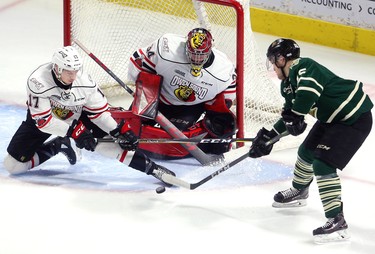 Cole Tymkin of the Knights tries a backhand in close on Owen Sound goalie Olivier Lafreniere with defenseman Trenton Bourque tries for the block during the first period of their playoff game on Monday March 26, 2018 at Budweiser Gardens.  Mike Hensen/The London Free Press/Postmedia Network