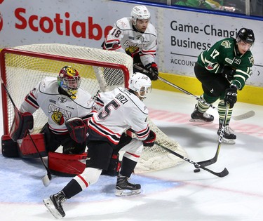 Nathan Dunkley of the Knights tries to move the puck in front of the net  while being defended by Owen Sound's Markus Phillips and Sean Durzi helping out their goalie Olivier Lafreniere  during the first period of their playoff game on Monday March 26, 2018 at Budweiser Gardens.  Mike Hensen/The London Free Press/Postmedia Network