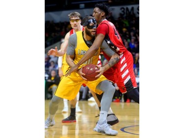 Royce White of the London Lightning was double-teamed often by Logan Stutz and Damontre Harris of the Windsor Express during the first half of their Wednesday night game at Budweiser Gardens in London, Ont.  Photograph taken on Wednesday March 28, 2018.  Mike Hensen/The London Free Press/Postmedia Network
