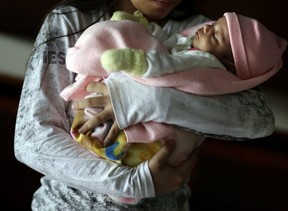 In this May 14, 2015 file photo, a 13-year-old girl holds her one-month-old baby at a shelter for troubled children in Ciudad del Este, Paraguay. The girl said she was raped by her stepfather from the time she was 10 and became pregnant when she was 12. Another pregnant girl, age 11, whose case drew international scorn when Paraguay's government denied her an abortion, gave birth on Aug. 13, 2015. The girl was allegedly raped and impregnated by her stepfather when she was 10. In Paraguay, abortion is banned except when the mother's life is in danger. (AP file photo)