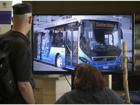 A pair of city residents watch a slideshow of photos at a public information session about Shift, a transportation initiative focused on rapid transit, at the Western Fair District Agriplex in May, 2015. (Free Press file photo)