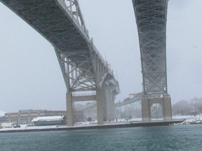 The two spans of the Blue Water Bridge are shown from the shore of the St. Clair River in Point Edward. Operators on both sides of the international crossing recently adjusted the exchange rate for tolls. (Paul Morden/Sarnia Observer/Postmedia Network)