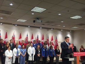 Ontario Finance Minister Charles Sousa with health-care professionals at a hospital funding announcement in Toronto on March 22, 2018.