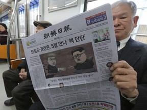 A passenger reads a newspaper with a headline of a planned summit meeting between North Korean leader Kim Jong-un and U.S. President Donald Trump on a subway in Seoul, South Korea, last week. Ahn Young-joon/AP Photo