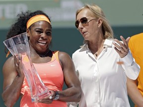 In this April 4, 2015, file photo, former tennis star Martina Navratilova, right, poses with Serena Williams, after Williams won the women's final match at the Miami Open. Navratilova says she is "angry" and feels let down by the BBC after learning that John McEnroe gets paid at least 10 times more than her for their broadcasting roles at Wimbledon.(Alan Diaz/AP Photo)