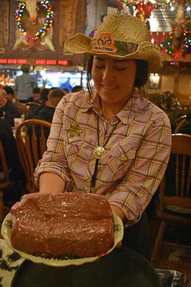 Aliah, a server at Amarillo's Big Texan Steak Ranch & Microbrewery, displays a raw 72-ounce steak that the restaurant cooks up and offers free if the diner can down it and "fixins" within one hour. Failure to complete the challenge results in a bill for $72. 

BARBARA TAYLOR/The London Free Press/Postmedia News