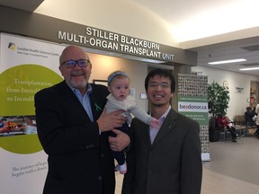 More than three years after doctors told his family he had just 24 hours to live, Doug Ferguson holds his granddaughter Mary next to the surgeon who helped save his life, Dr. Douglas Quan, who was called in to transplant a second liver after Ferguson's immune system rejected the first.